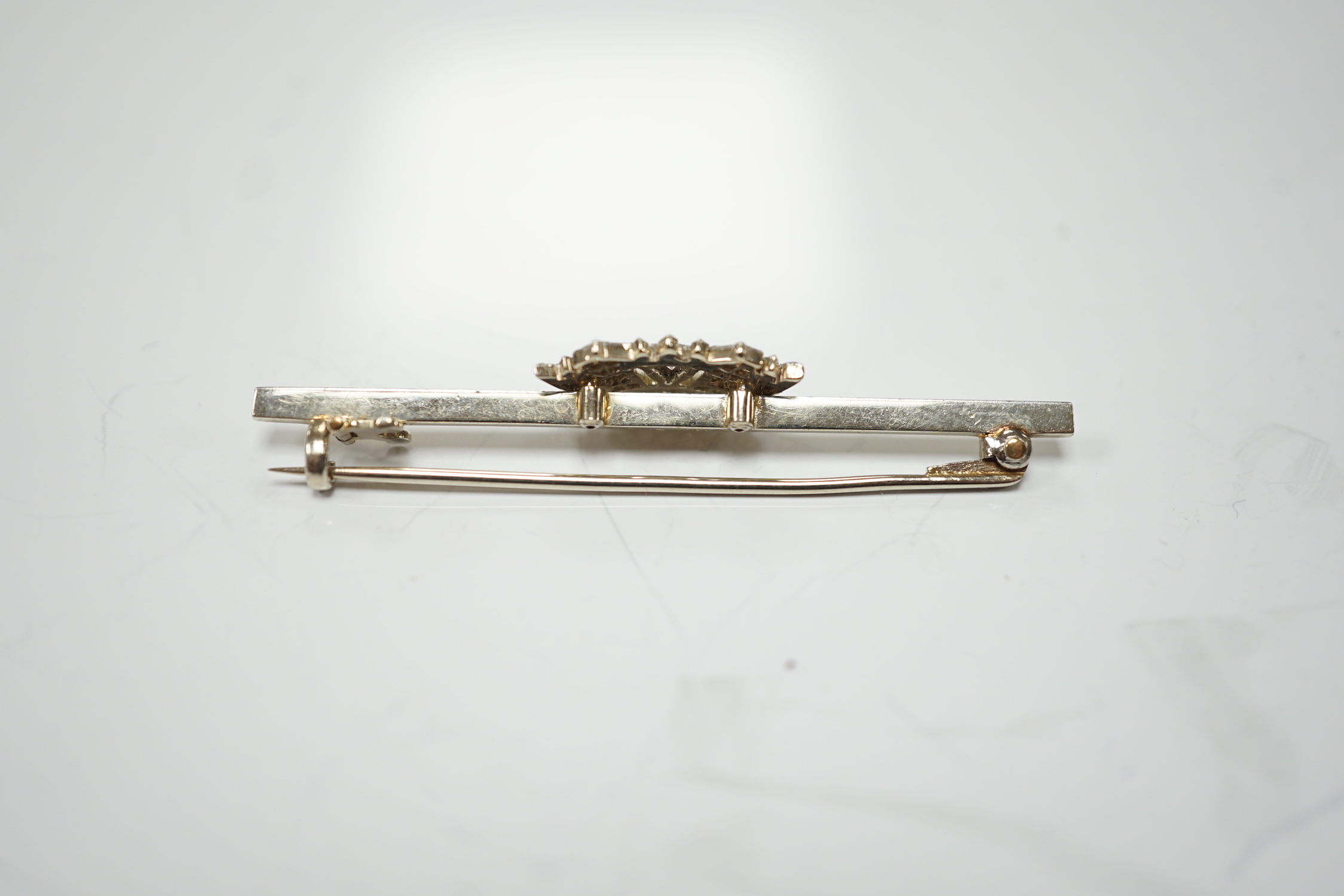 A 1940's white metal (stamped 14ct and platinum) and diamond cluster set coronet bar brooch, 50mm, gross weight 4.1 grams.